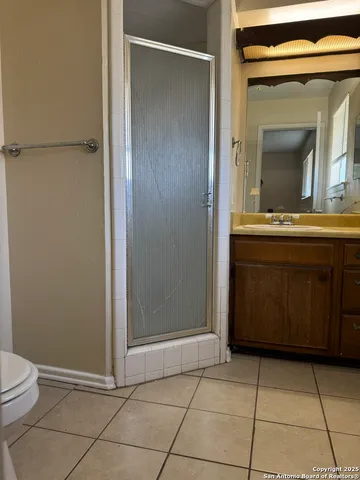 a bathroom with a granite countertop sink a toilet and mirror