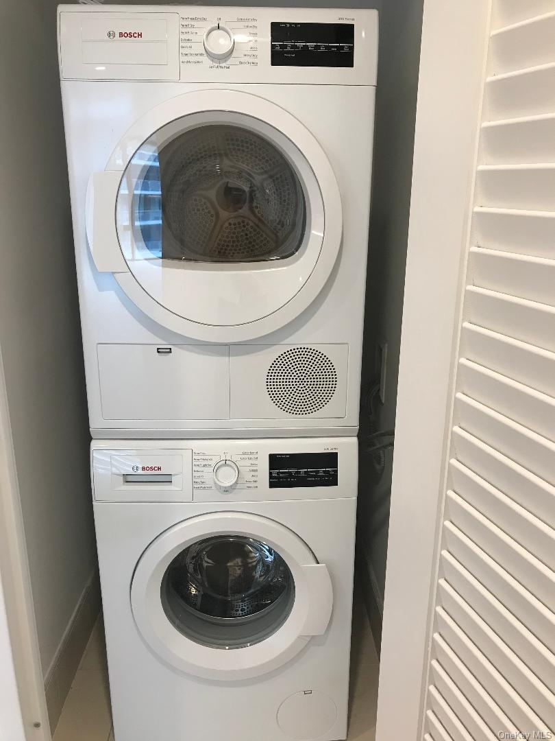 131-03 40 Road, Unit 10Q Queens, NY 11354 - Photo 15 of 15 a utility room with dryer and washer