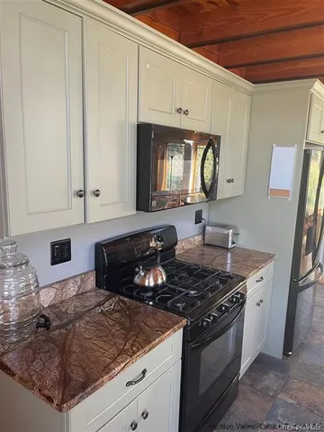 a kitchen with granite countertop a stove a sink and a microwave