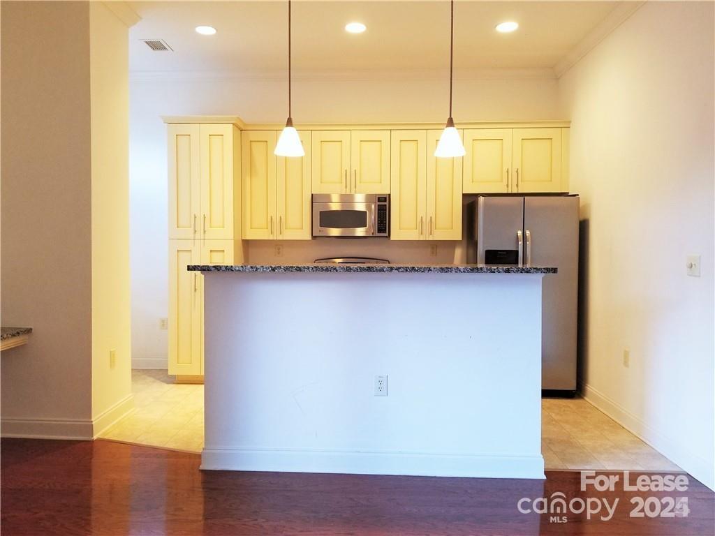 230 South Tryon Street Charlotte, NC 28281 - Photo 7 of 12 a kitchen with stainless steel appliances granite countertop a sink a stove top oven a counter space and cabinets
