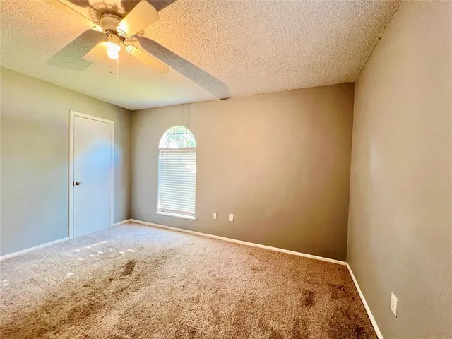 a view of an empty room with a ceiling fan