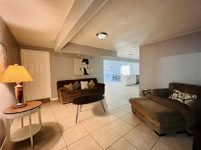 a kitchen with stainless steel appliances a dining table chairs and a refrigerator