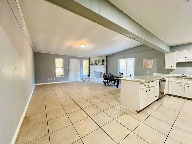 a kitchen with granite countertop a refrigerator and a stove top oven