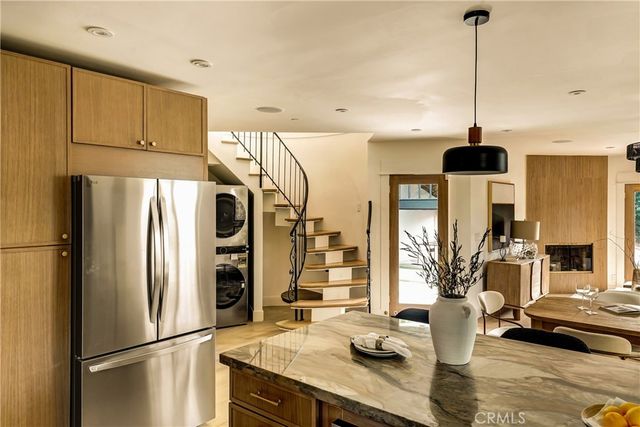 a kitchen with stainless steel appliances granite countertop a refrigerator a sink and white cabinets