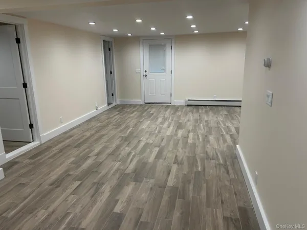 a view of an empty room with wooden floor