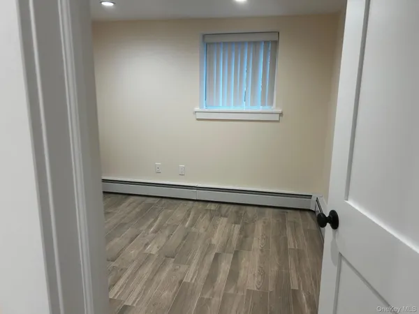 a view of a room with wooden floor and front door