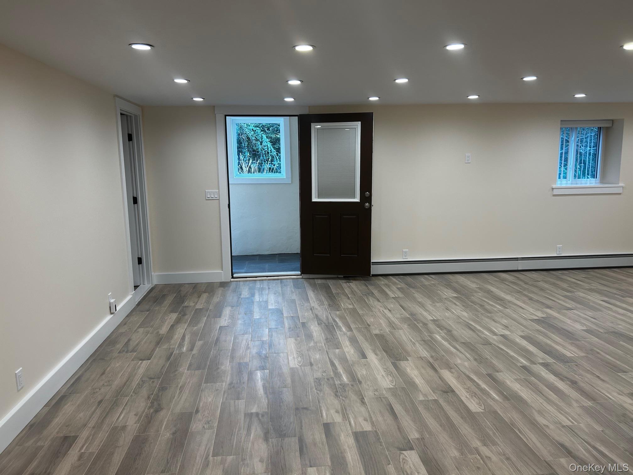 65 Linwood Road North, Unit GARDEN Port Washington, NY 11050 - Photo 10 of 11 Living room featuring recessed lighting, wood finished floors, and a baseboard heating unit