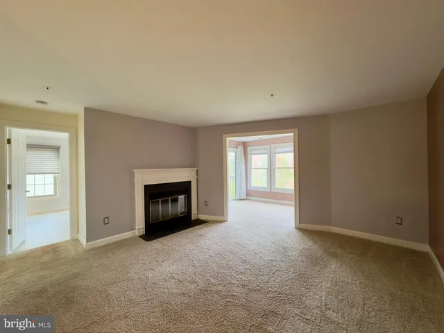 an empty room with a fireplace and a window