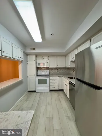 a kitchen with a refrigerator a sink dishwasher with a oven and cabinets