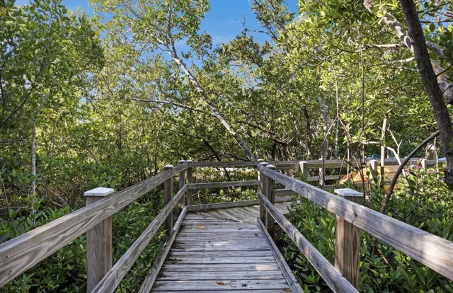 a view of a patio with table and chairs potted plants with wooden floor and fence