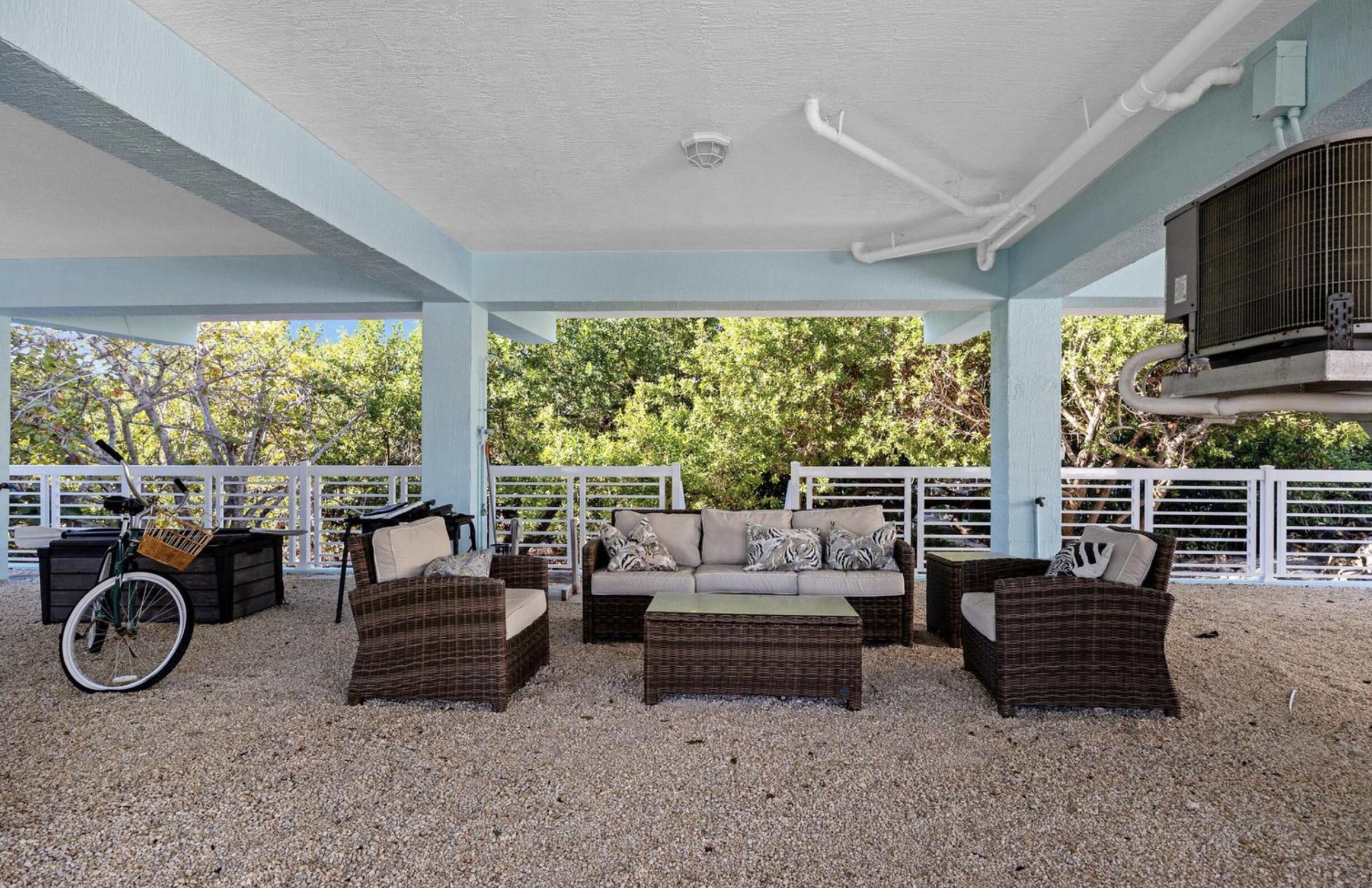 102 Venetian Drive Islamorada, FL 33036 - Photo 4 of 29 a living room with furniture a flat screen tv and a floor to ceiling window