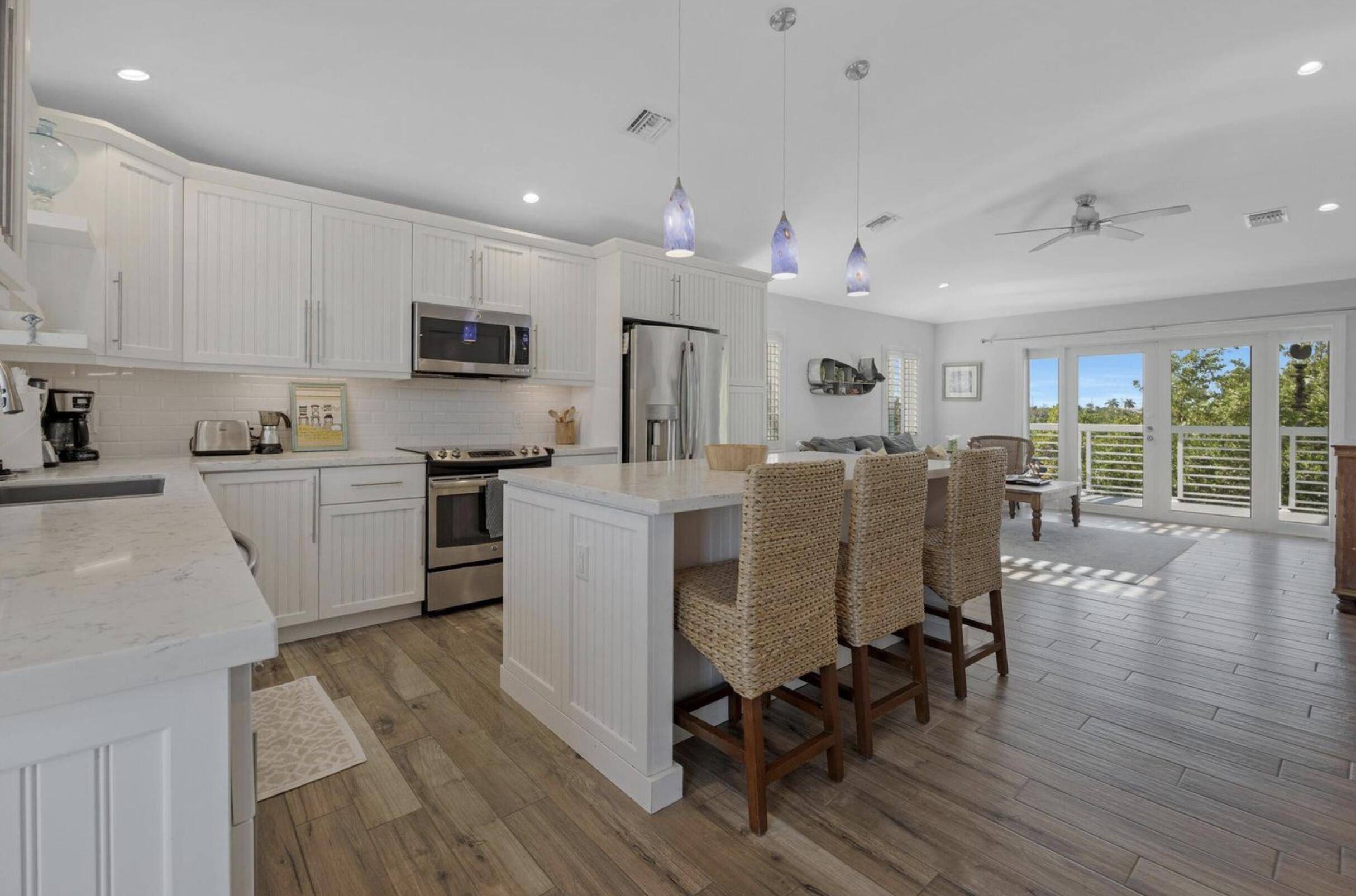 102 Venetian Drive Islamorada, FL 33036 - Photo 6 of 29 a kitchen with a table chairs microwave and cabinets