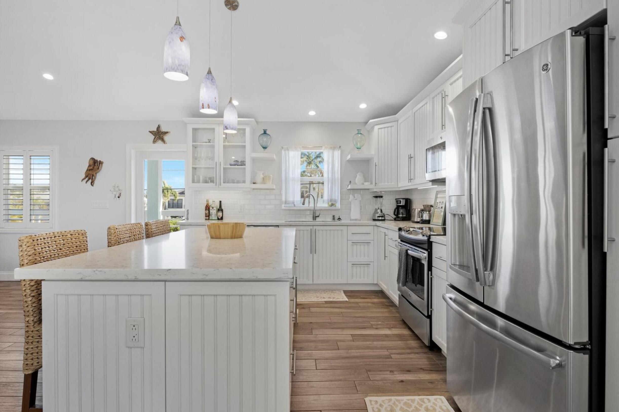 102 Venetian Drive Islamorada, FL 33036 - Photo 9 of 29 a kitchen with white cabinets and stainless steel appliances