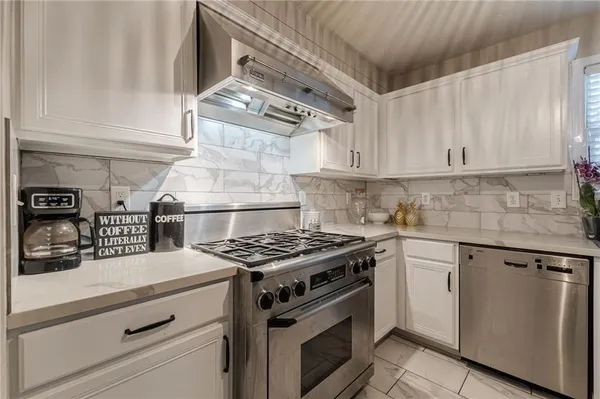 a kitchen with granite countertop stainless steel appliances and white cabinets