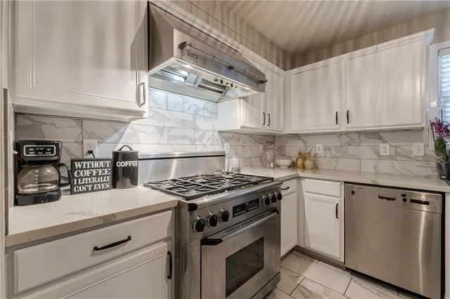 a kitchen with granite countertop stainless steel appliances and white cabinets