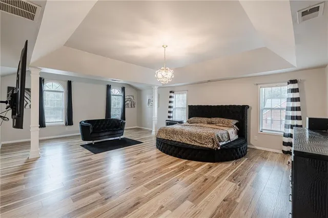 a spacious bedroom with a bed and a television