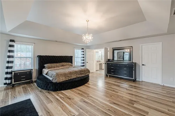 a spacious bedroom with a bed and a television