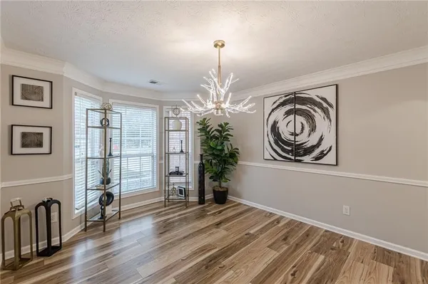 a view of a livingroom with wooden floor windows and a chandelier