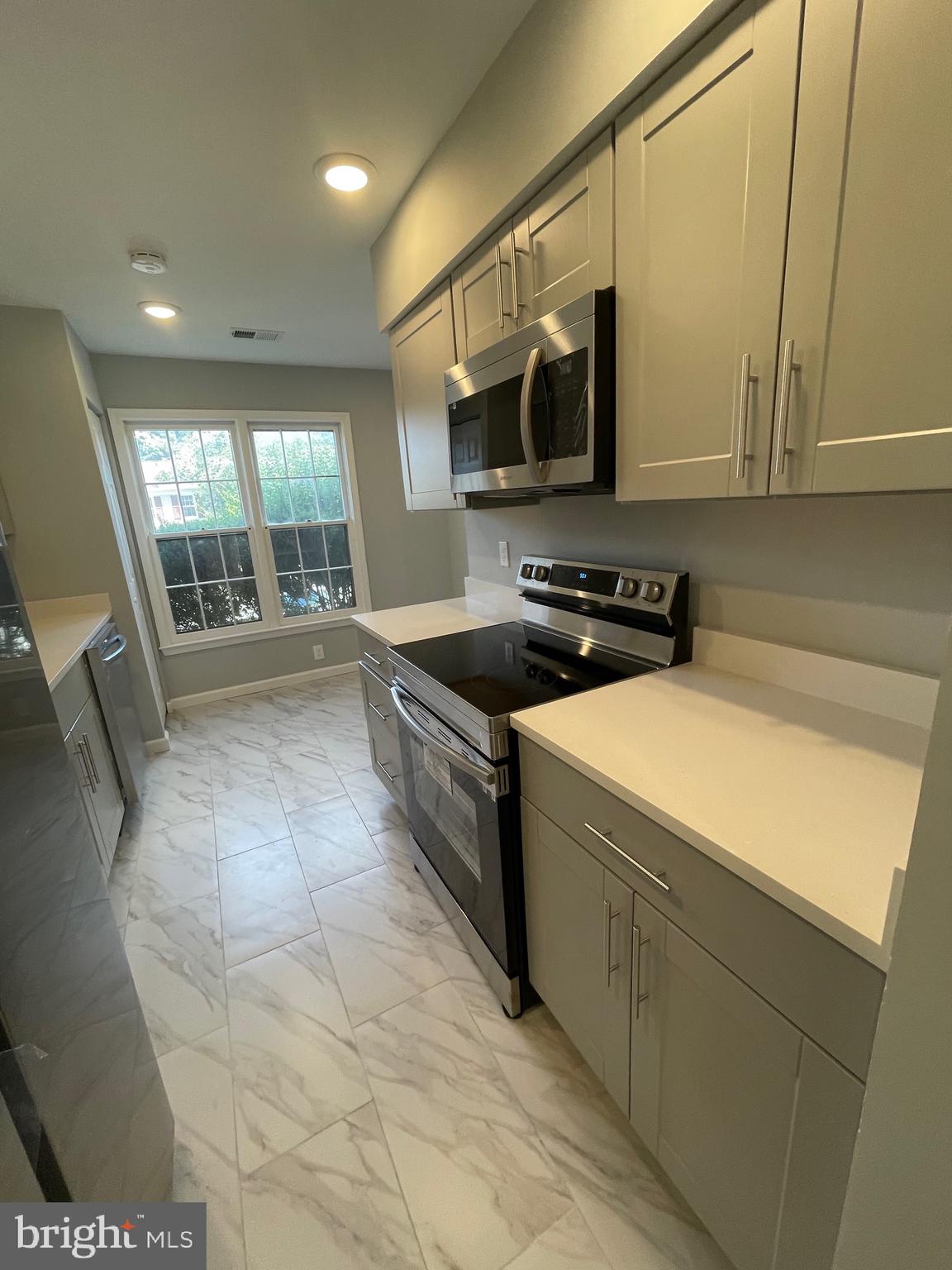 124 Andrew Place Sterling, VA 20164 - Photo 28 of 70 a kitchen with stainless steel appliances a stove a sink a microwave a refrigerator and cabinets