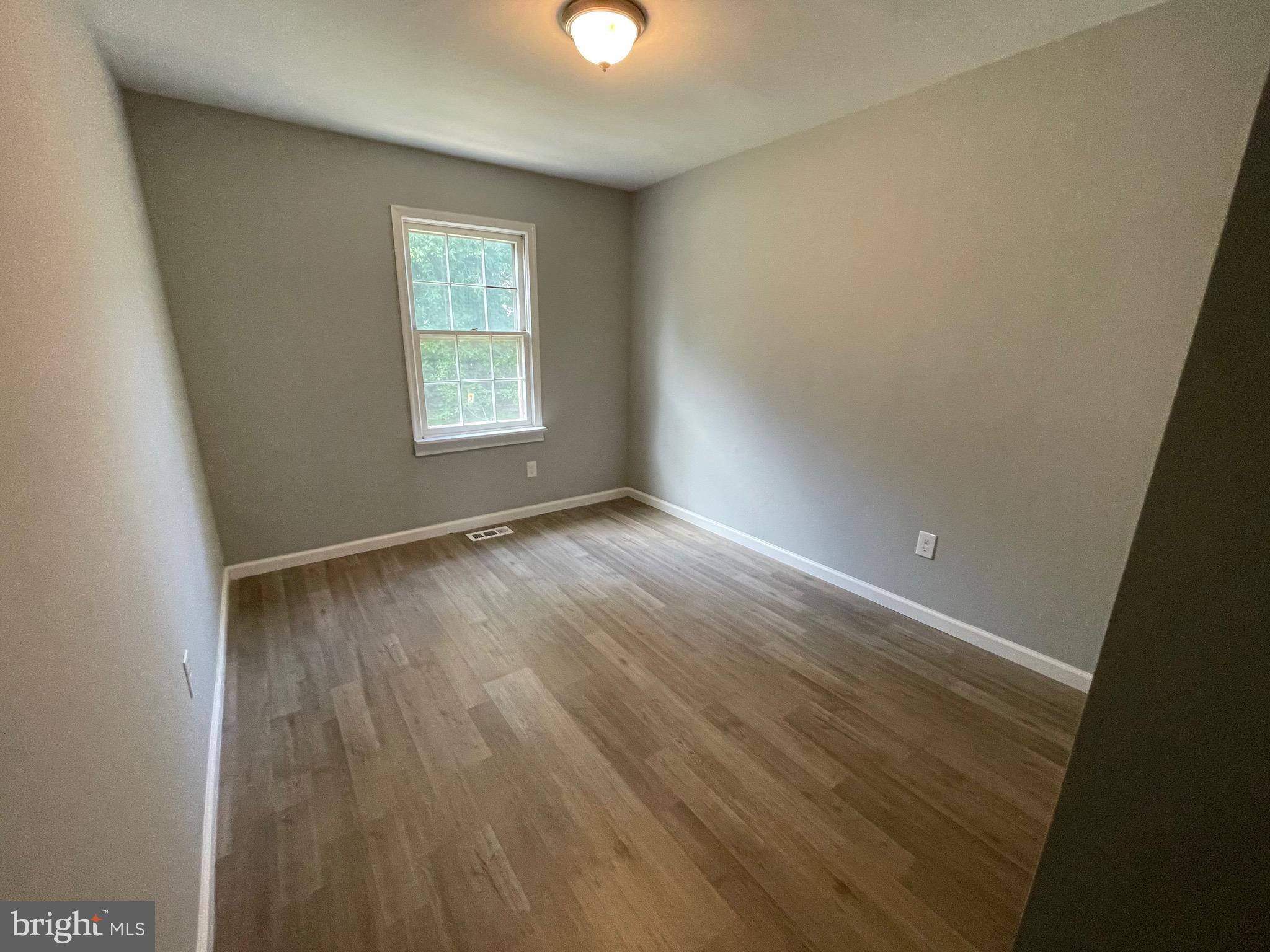 124 Andrew Place Sterling, VA 20164 - Photo 51 of 70 an empty room with wooden floor and windows