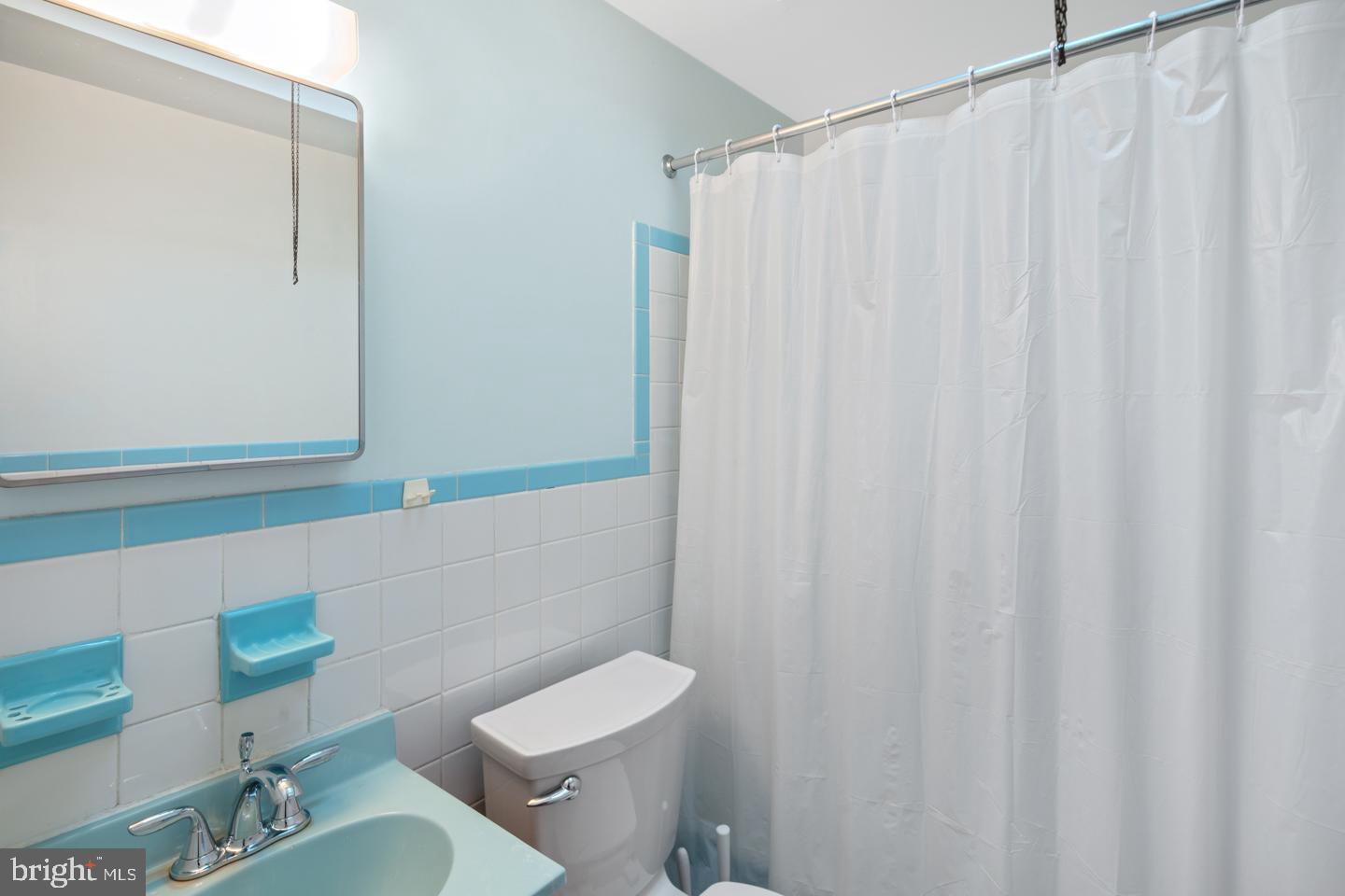 10803 Pedrick Road Philadelphia, PA 19154 - Photo 17 of 25 a bathroom with a sink a toilet a mirror and shower curtain