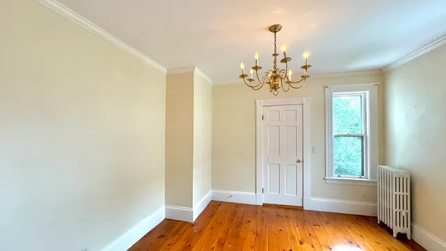 a view of a room with window wooden floor and chandelier