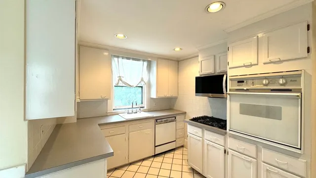 a kitchen with white cabinets and white appliances