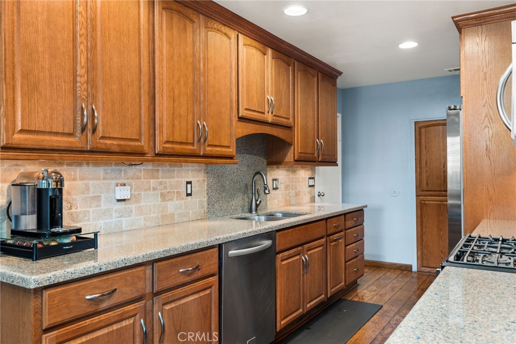 7221 Ramona Avenue Rancho Cucamonga, CA 91701 - Photo 7 of 30 a kitchen with stainless steel appliances granite countertop a sink a stove and a refrigerator