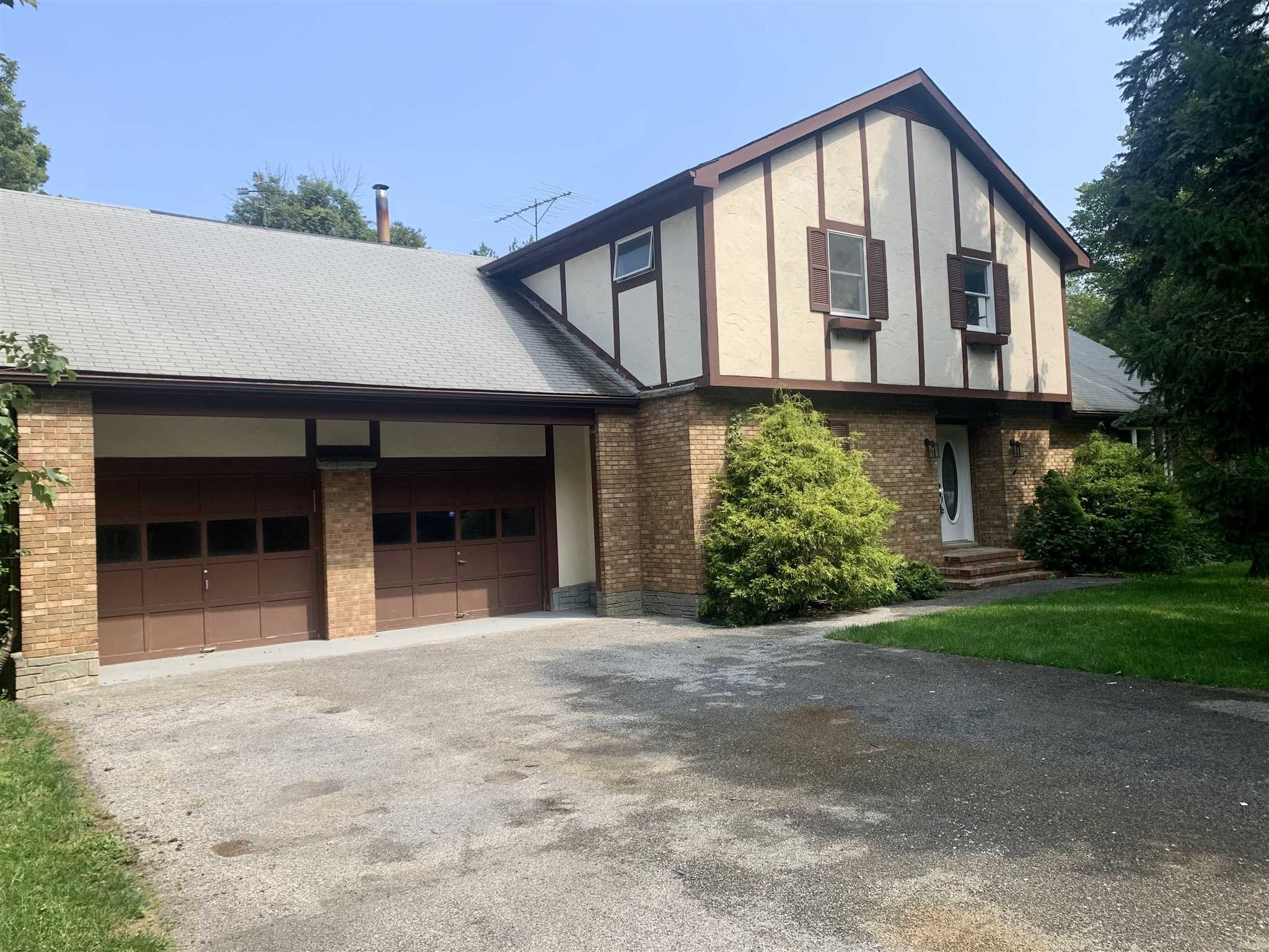 a front view of a house with a garden and garage