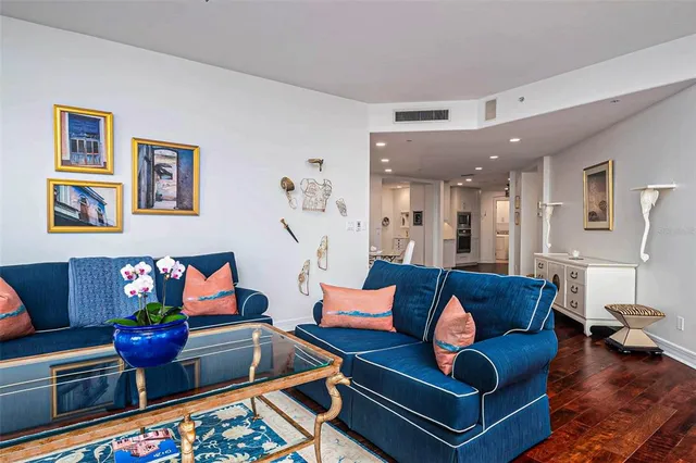 a living room with furniture a rug and a floor to ceiling window