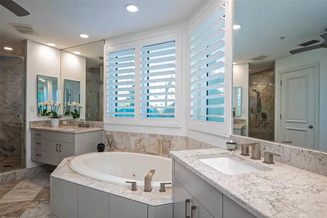 a bathroom with a bathtub sink mirror vanity and toilet