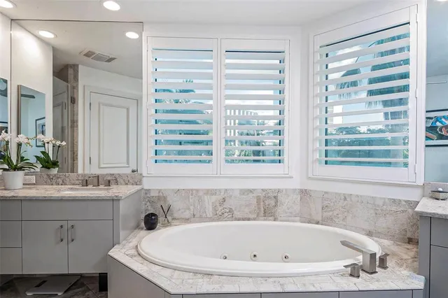 a bathroom with a bathtub sink and mirror
