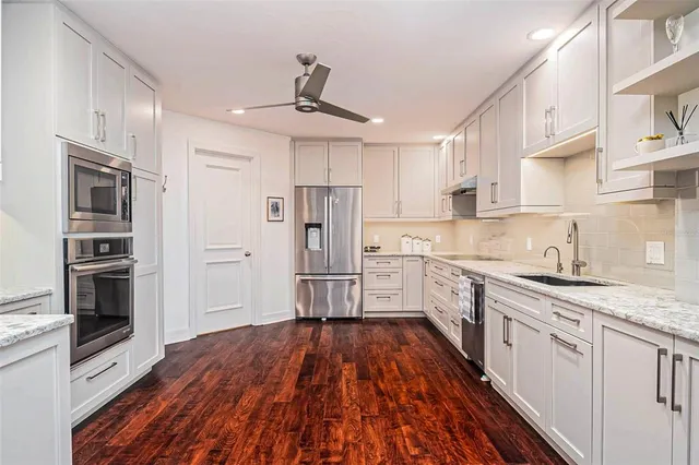 a view of a kitchen with refrigerator and wooden floor