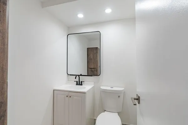 a bathroom with a toilet sink and mirror