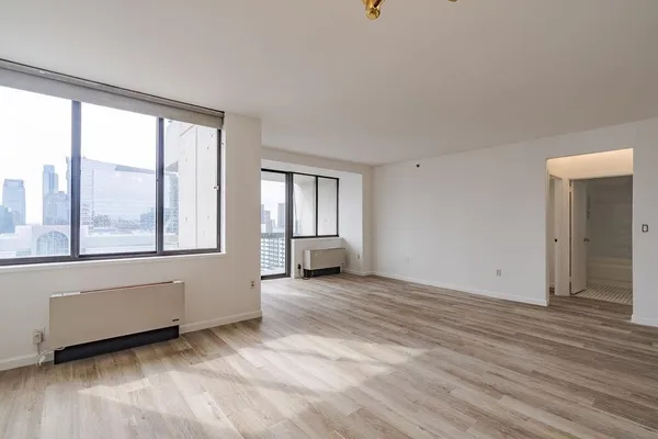 an empty room with wooden floor and windows