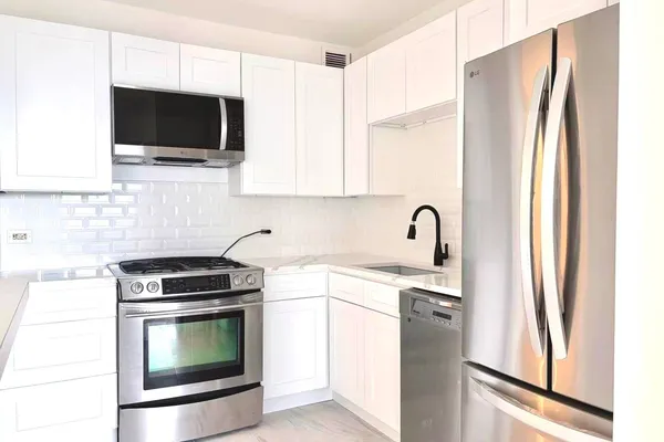 a kitchen with stainless steel appliances a stove microwave and a sink