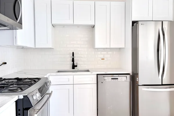 a kitchen with stainless steel appliances granite countertop a refrigerator sink and stove