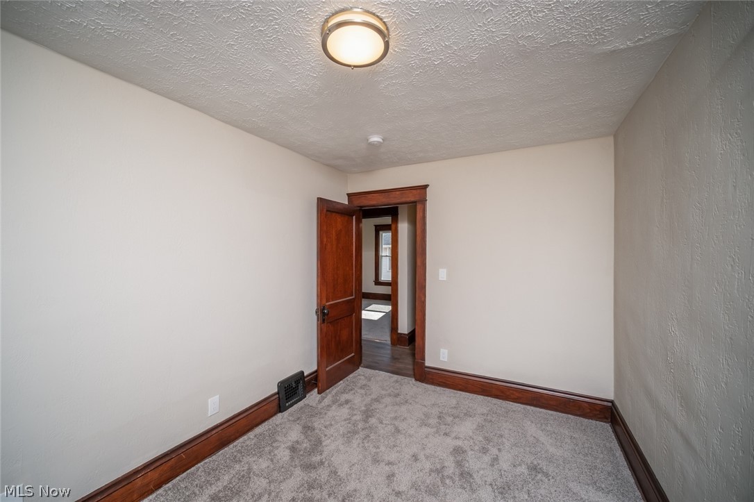 809 Wales Road Northeast Massillon, OH 44646 - Photo 13 of 15 Spare room featuring carpet and a textured ceiling