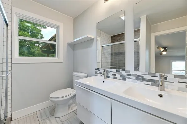 a bathroom with a sink a toilet and a mirror