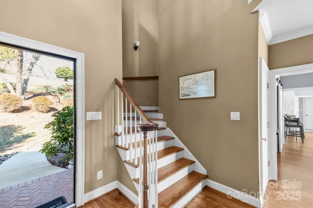 a view of a hallway with wooden floor and windows