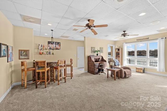 a living room with furniture a fireplace and a floor to ceiling window