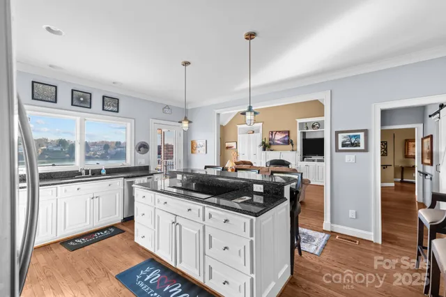 a kitchen with stainless steel appliances granite countertop a stove a sink and a refrigerator