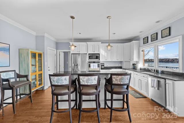 a kitchen with stainless steel appliances a dining table chairs stove and refrigerator