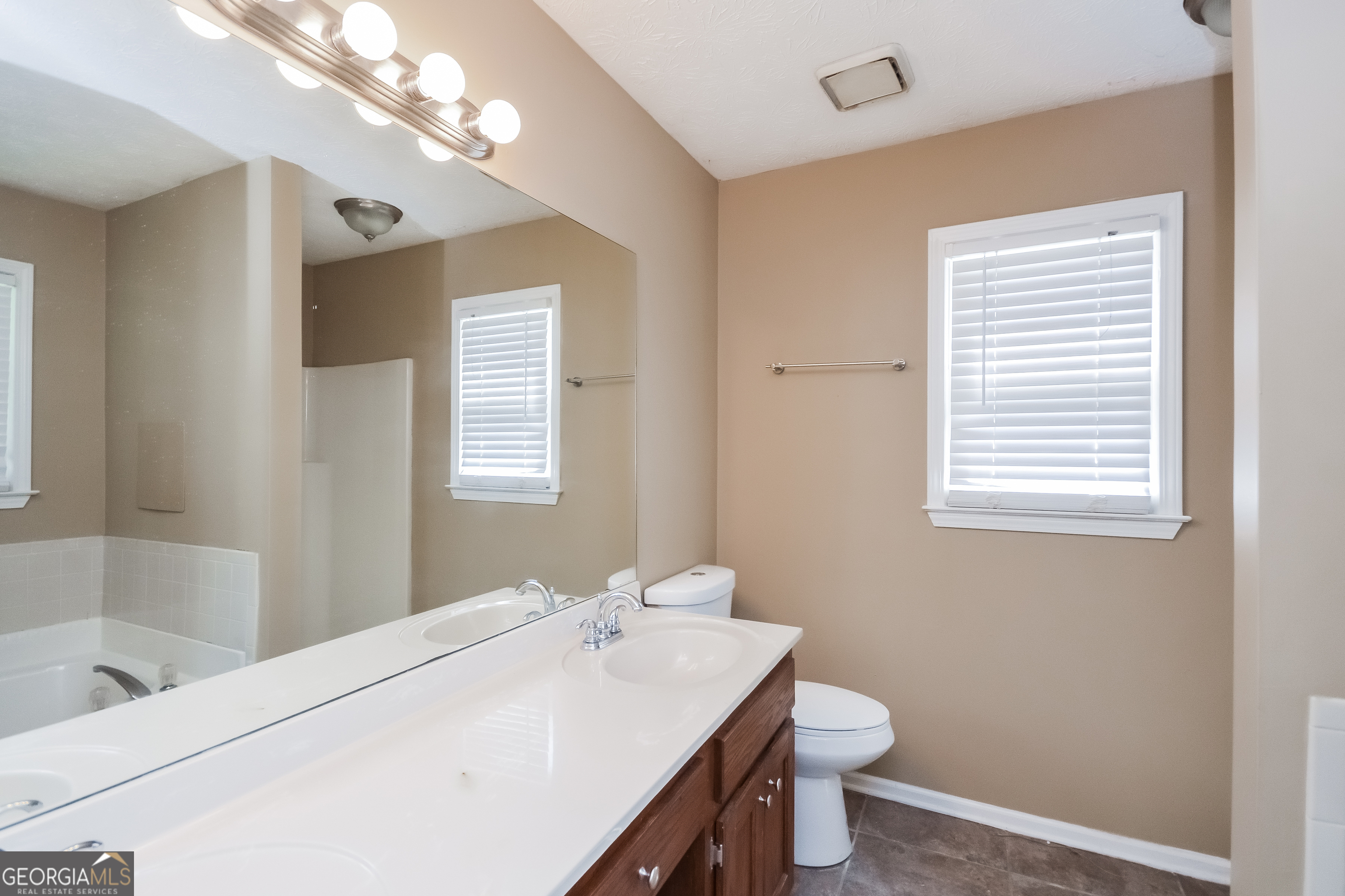 2451 Sherrie Lane Southwest Conyers, GA 30094 - Photo 10 of 17 a bathroom with a sink a toilet and a mirror