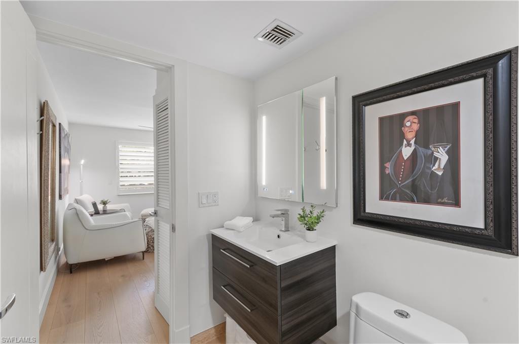568 12th Avenue South, Unit 568 Naples, FL 34102 - Photo 16 of 34 a view of a bathroom with a sink a toilet and a mirror
