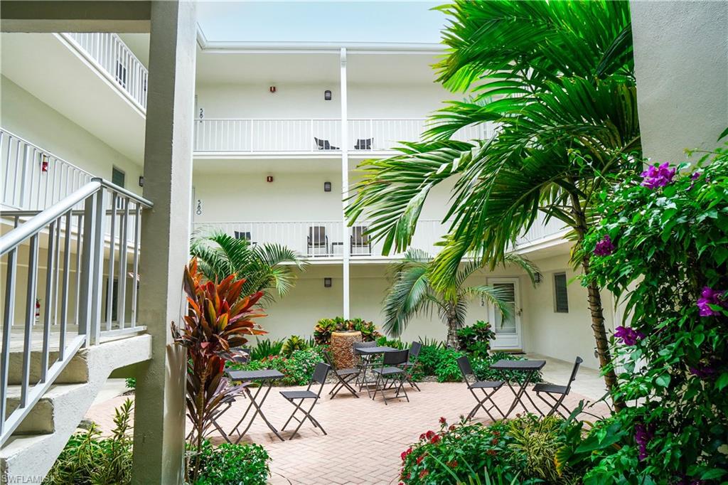568 12th Avenue South, Unit 568 Naples, FL 34102 - Photo 25 of 34 a view of a chair and tables in the patio