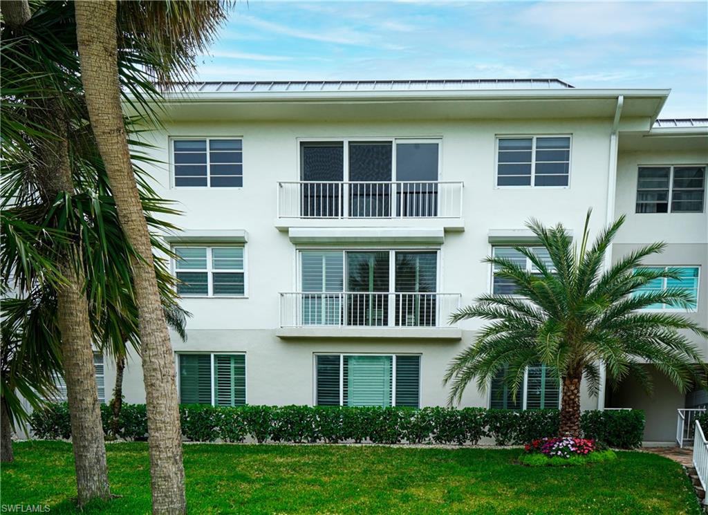 568 12th Avenue South, Unit 568 Naples, FL 34102 - Photo 26 of 34 a front view of a house with a yard and potted plants