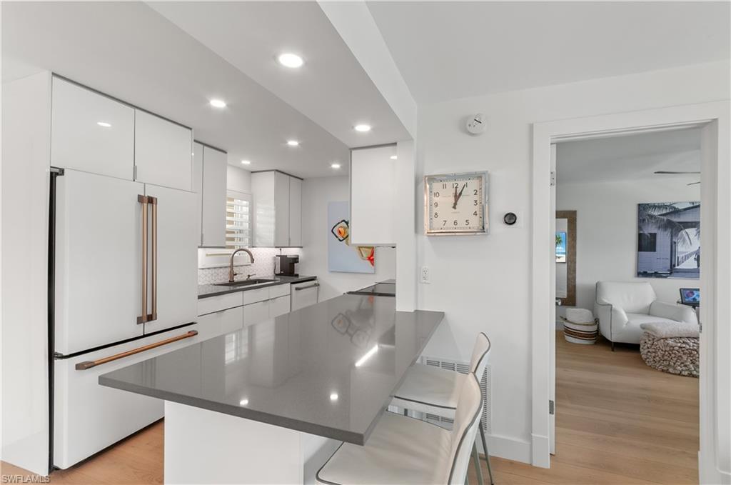 568 12th Avenue South, Unit 568 Naples, FL 34102 - Photo 3 of 34 a large kitchen with stainless steel appliances a refrigerator and wooden floor