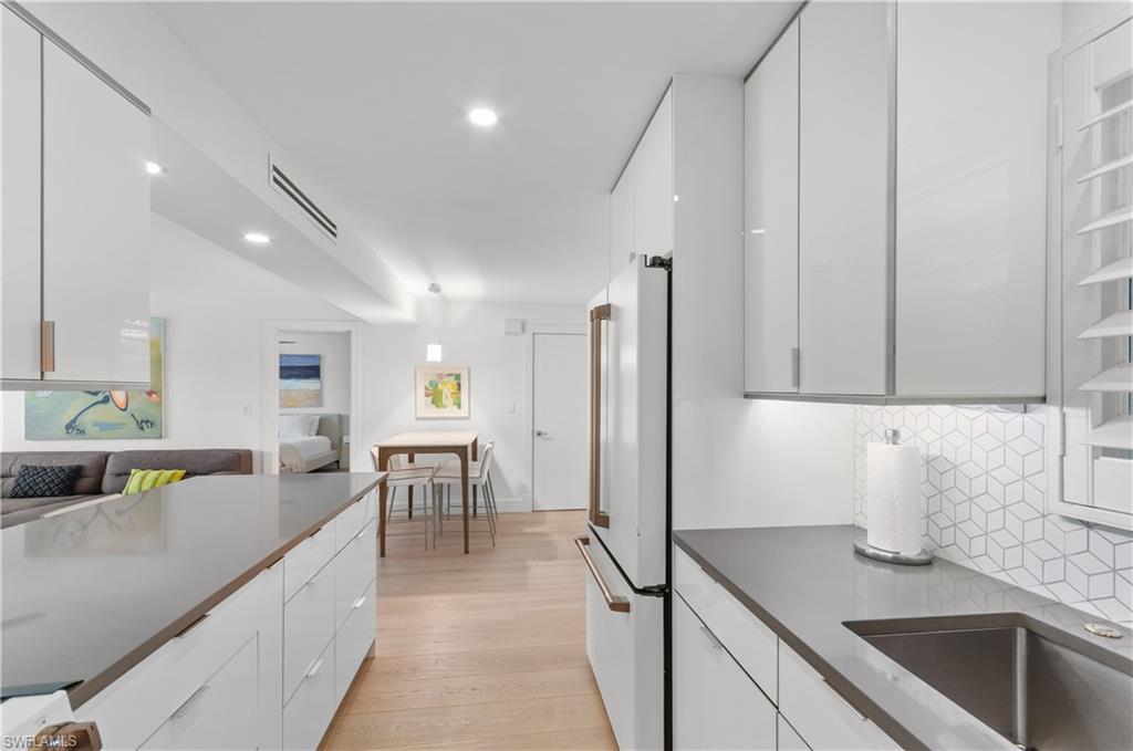 568 12th Avenue South, Unit 568 Naples, FL 34102 - Photo 5 of 34 a kitchen with kitchen island granite countertop a sink a counter top space and stainless steel appliances