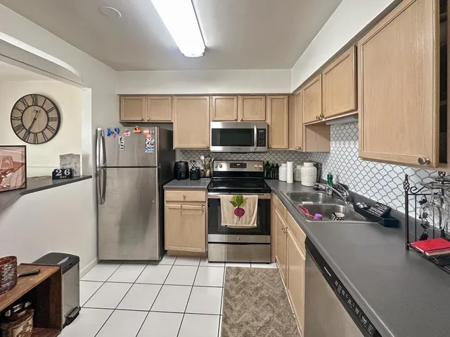 a kitchen with a refrigerator a stove and a sink